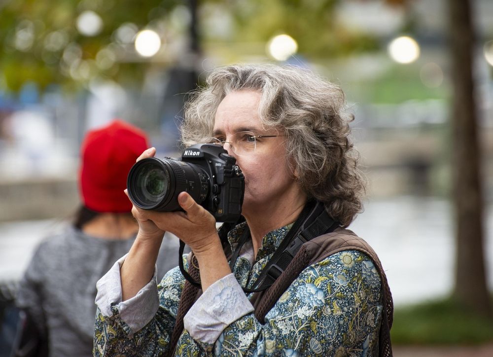Woman with Nikon camera held near her face