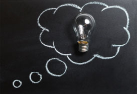 Chalkboard with an outline of a thought bubble with a lightbulb in the center